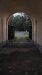 View through the gates, the fort is half-full of thriving forest along with the buildings.