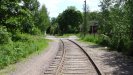 Going to the left to follow the single track which heads towards the mainline and a rail yard, amidst a residential area.